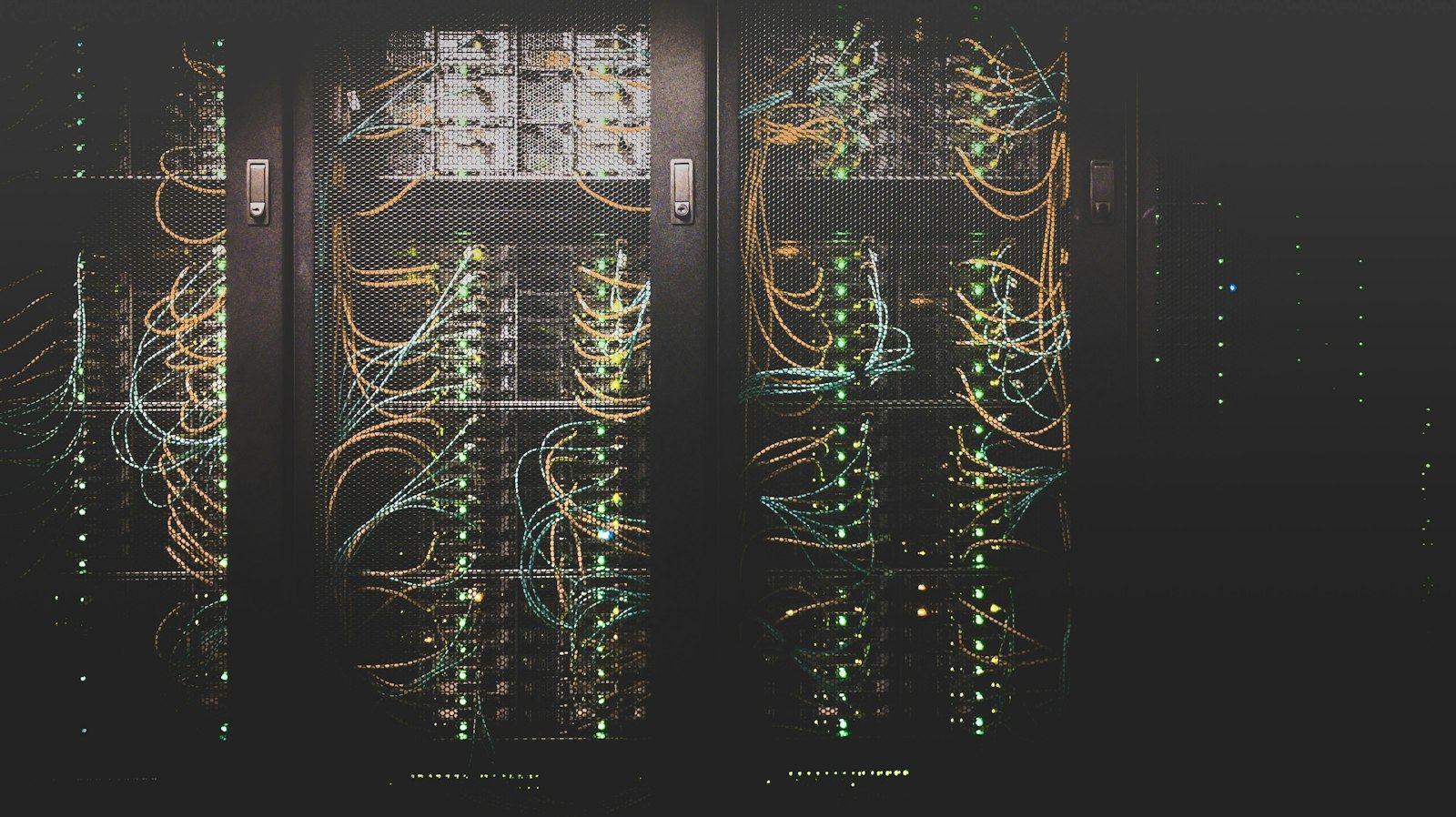 Server racks in the dark, activity LEDs glowing